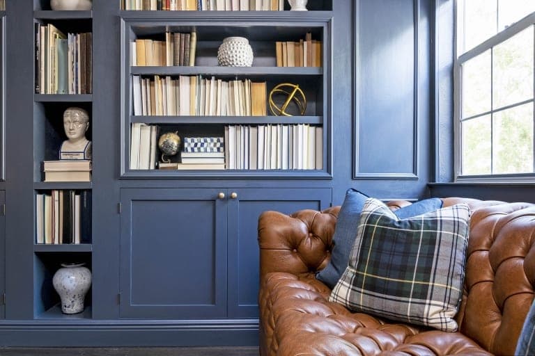 Kristine Bishop Design Dark Blue Book Shelf Cabinets Brown Leather Couch Blue Cushions Tartan Pillows